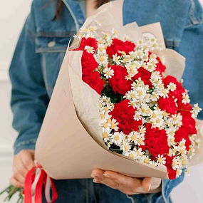 Букет из 15 красных гвоздик и 7 матрикарий в кремовой пленке